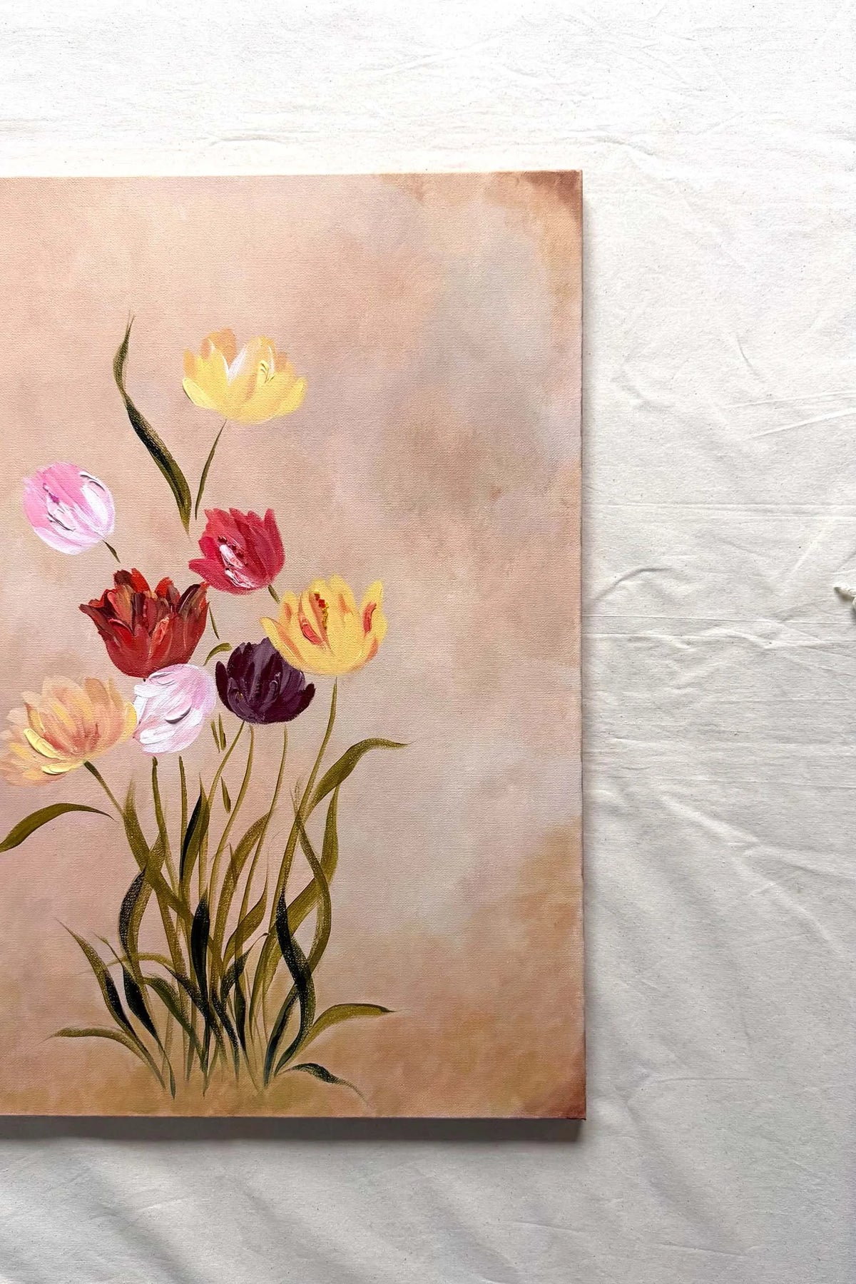 A original canvas painting featuring a cluster of colorful tulips, including yellow, pink, red, and purple flowers with green stems, set against a textured beige background.