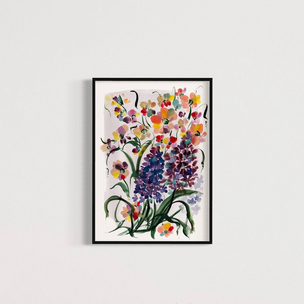Purple hyacinth and colorful floral print in a black frame on a pale wall.