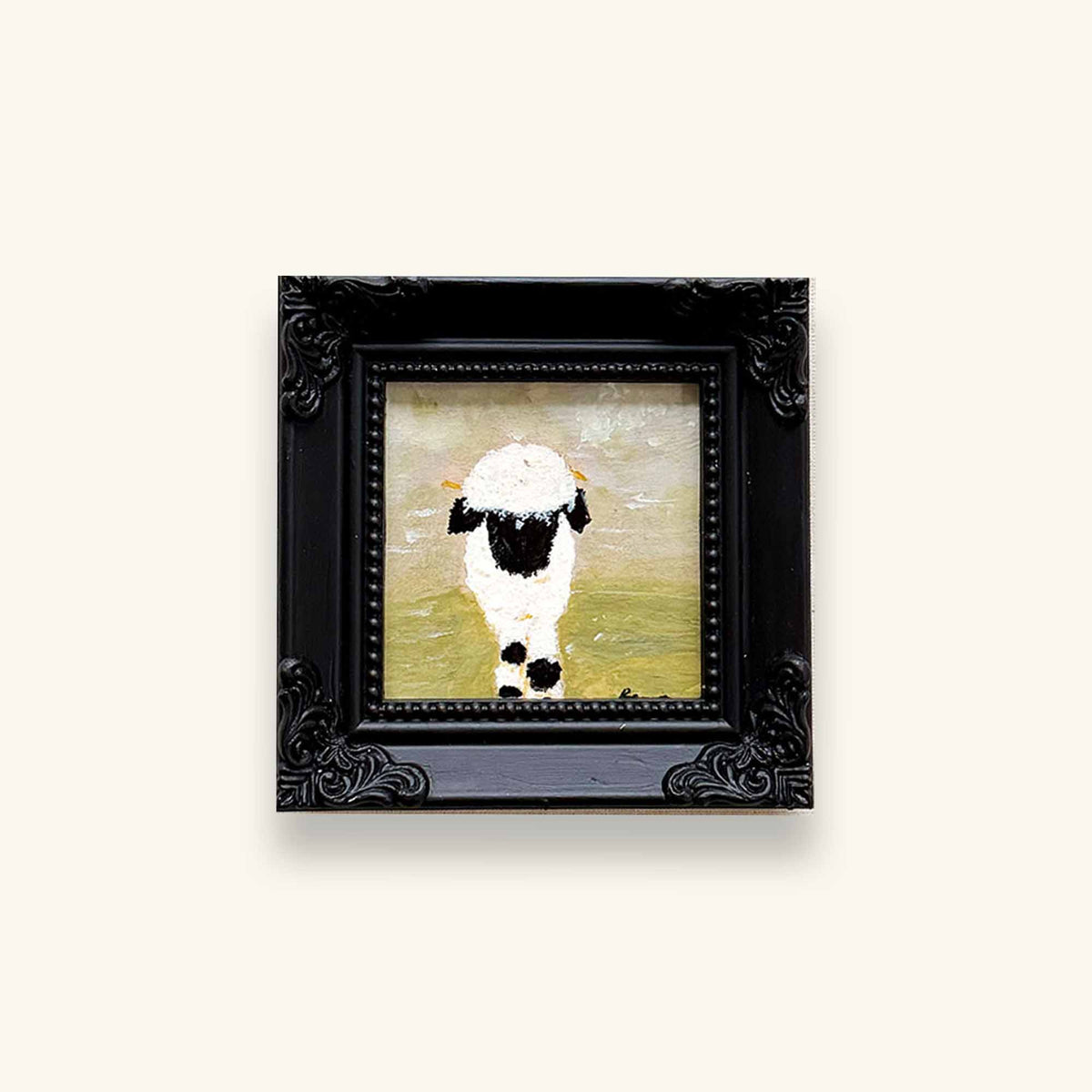 A small framed art original featuring a black and white sheep on a soft yellow-green background, enclosed in an ornate black frame 