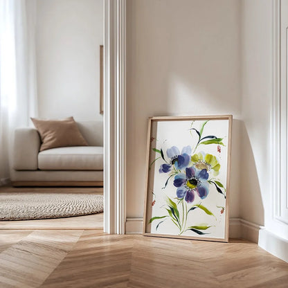 Blue anemone print in a light wood frame leaning against a hallway wall.