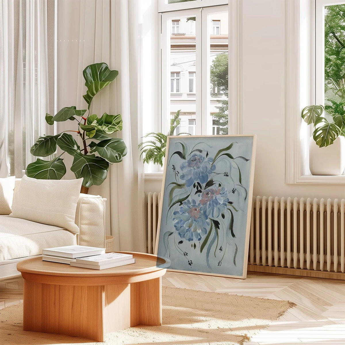 Large blue ranunculus print leaning beside a radiator in a bright living room with plants.