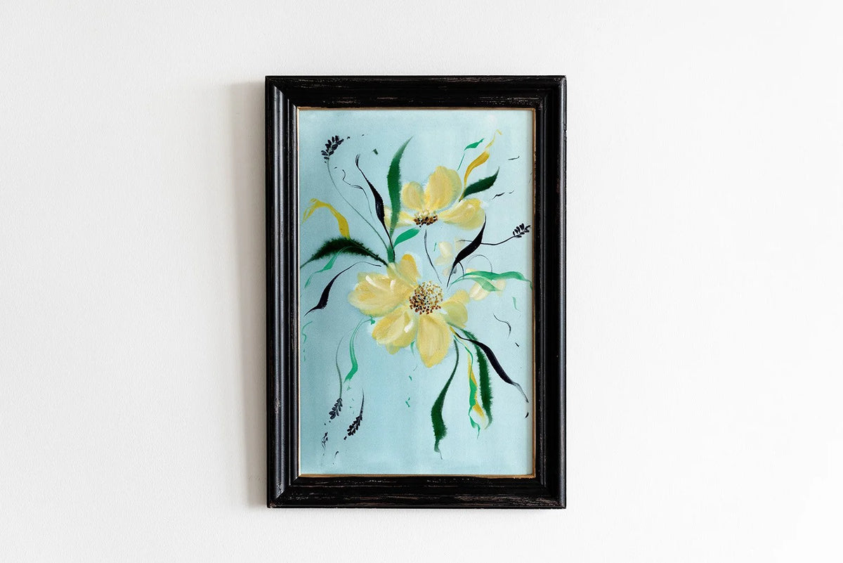 Yellow wildflower print on pale blue in a black frame.