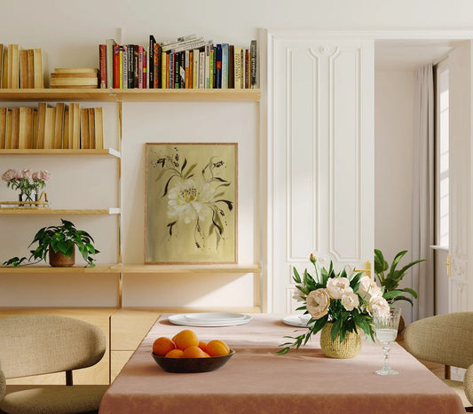 Golden-background white peony print displayed on a bookshelf behind a dining table.