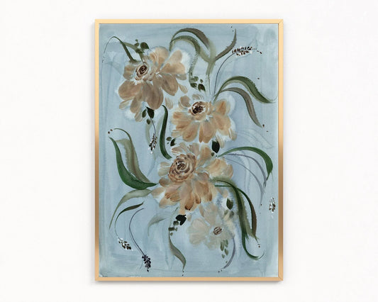Gold-framed print of beige and brown ranunculus with sweeping green leaves on pale blue.