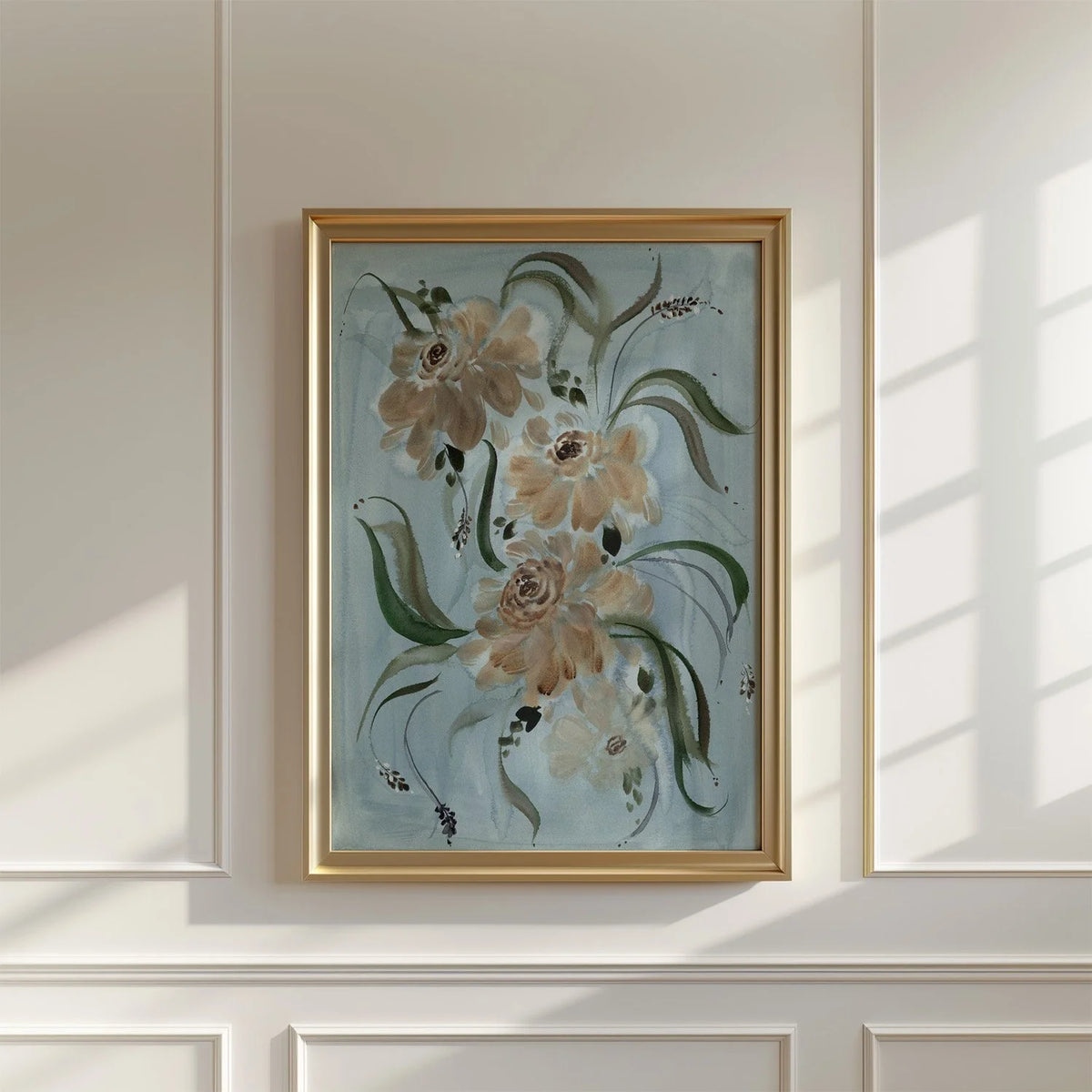 Brown ranunculus print in a brass-colored frame on a sunlit paneled wall.