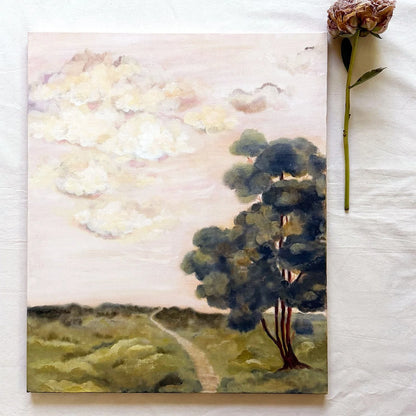 A original painting of a pastoral landscape with a pale pink sky, soft clouds, green fields, and a large dark tree beside a winding path. 