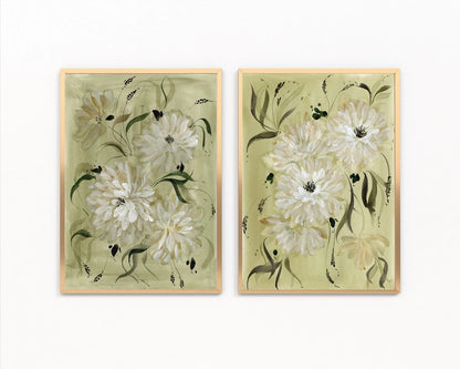 Two gold-framed prints of white dahlias and slender green leaves on sage backgrounds.