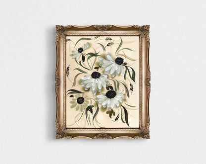 White daisy print in an ornate gold frame on a pale wall.