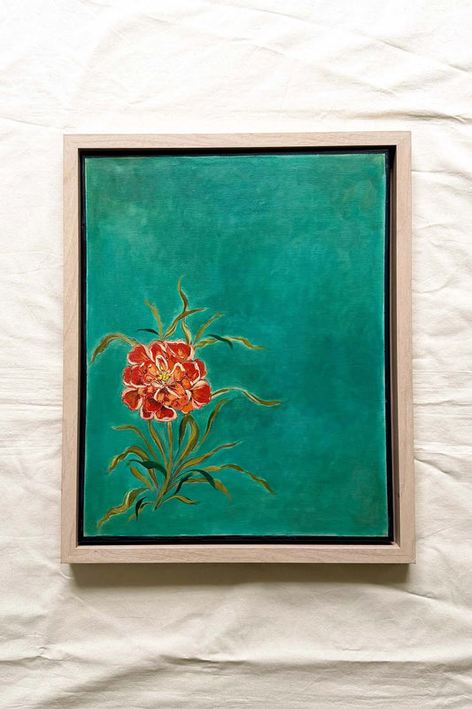 A framed painting featuring a vibrant red and orange flower with green leaves on a textured teal background, housed in a light natural wood frame . Original artwork by Ramya Rajiv