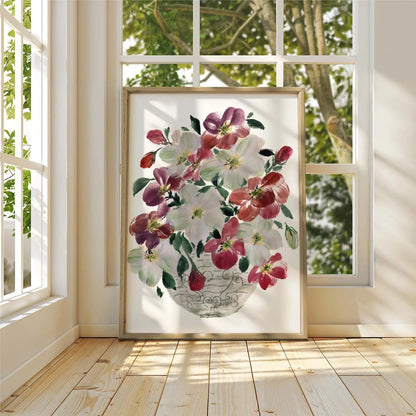 Framed burgundy and white hellebore bouquet print leaning against a sunlit window.