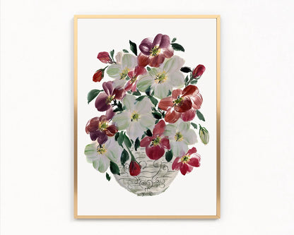 Gold-framed print of burgundy and white hellebores in a patterned rounded vase.