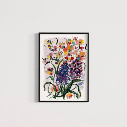 Purple hyacinth and colorful floral print in a black frame on a pale wall.