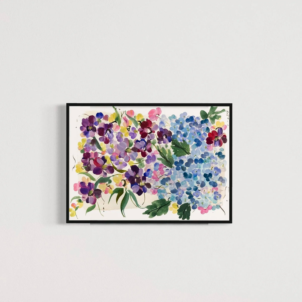 Colorful hydrangea and floral art print in a black frame on a pale gray wall.