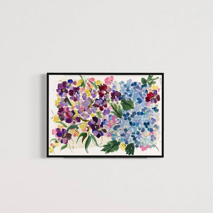 Colorful hydrangea and floral art print in a black frame on a pale gray wall.