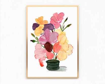Gold-framed print of pink, yellow and purple irises in a dark green vase.
