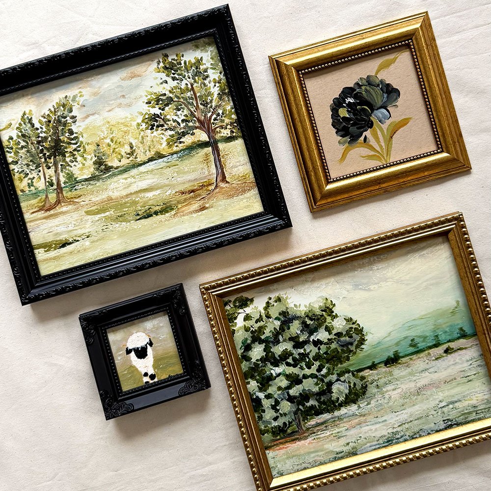Four framed original paintings. The set includes two landscape paintings with textured oil-style brushstrokes, one black-framed landscape, one gold-framed floral painting, and one black-framed sheep painting.