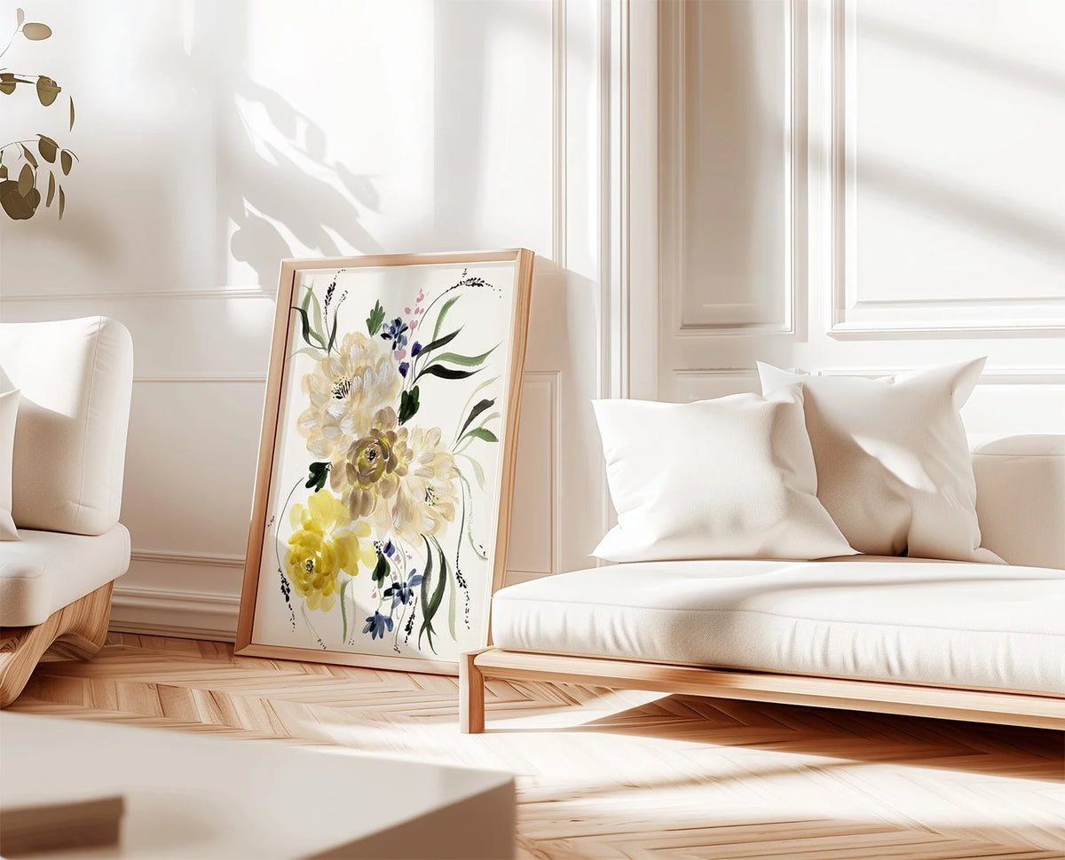 Cream and yellow floral print leaning against white wall panels beside a white sofa.