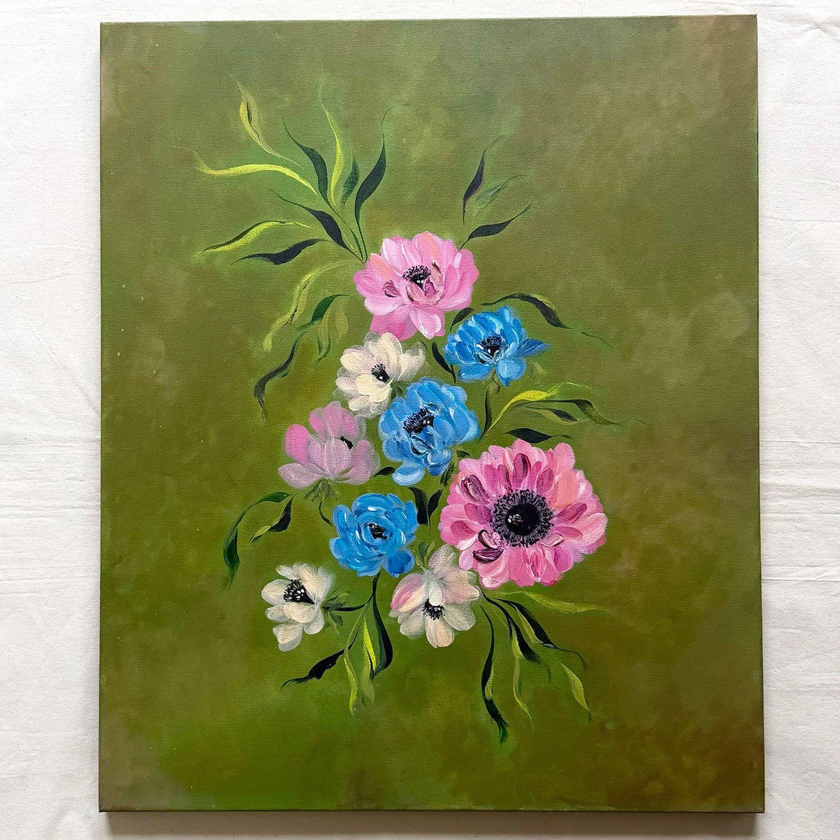 A large canvas original painting featuring a cluster of anemone flowers in pink, blue, and white with green leaves on a textured olive green background