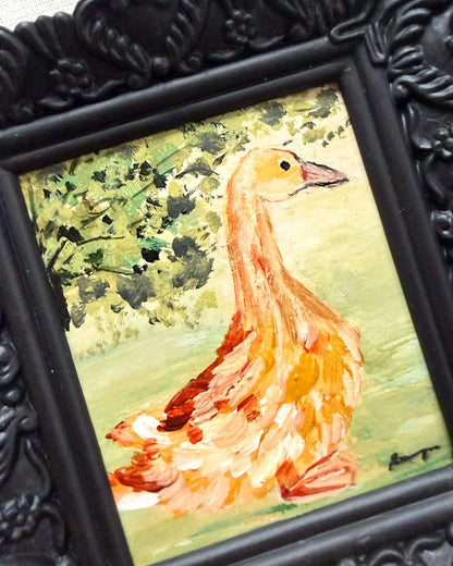 A framed hand-painted original painting of a goose, featuring a textured black ornate frame.
