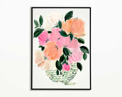 Black-framed print of pink, peach and cream peonies with green leaves in a patterned vase.