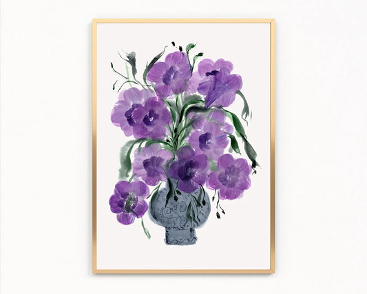 Gold-framed print of purple petunias in a decorative blue-gray vase.