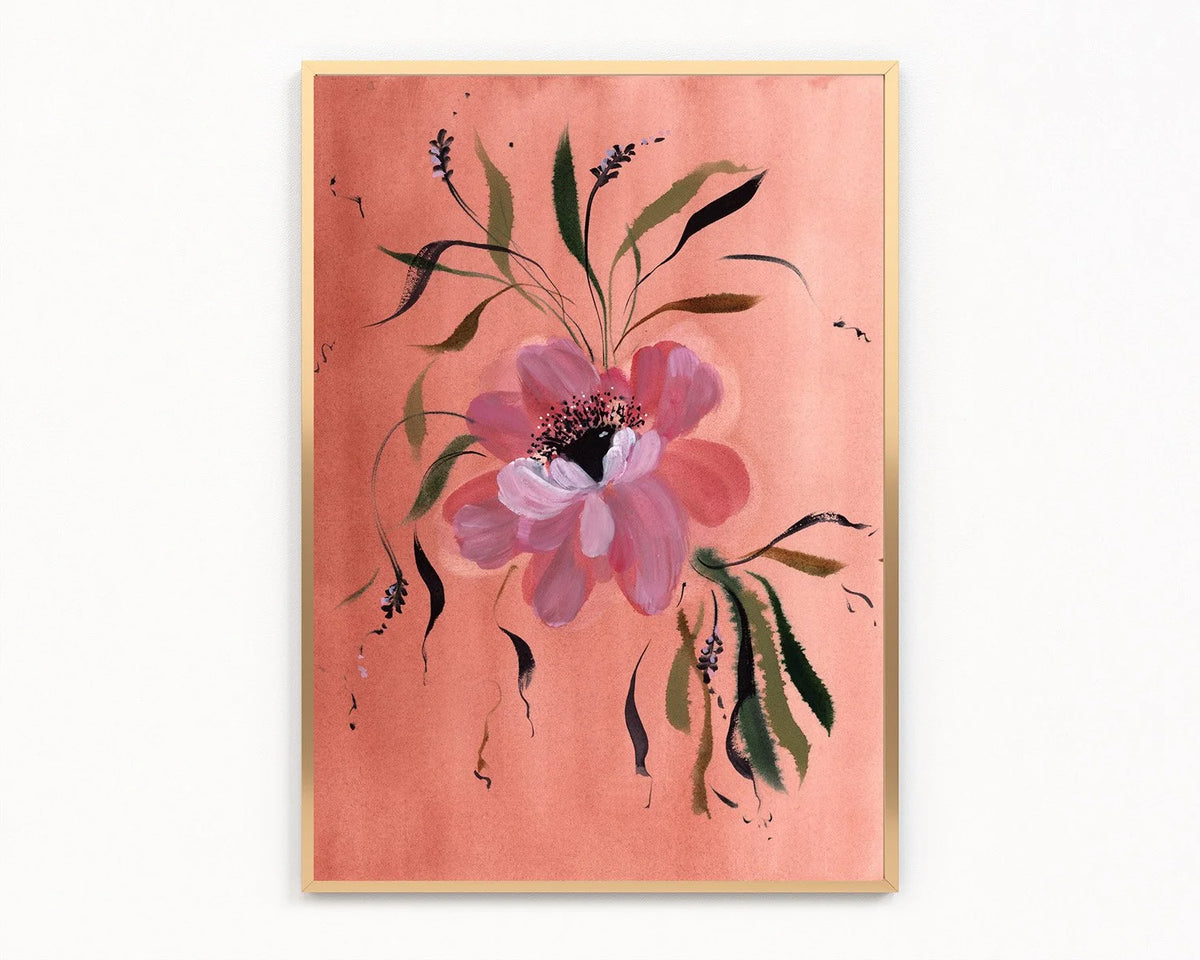 Gold-framed print of a pink anemone with a dark center and green leaves on coral.