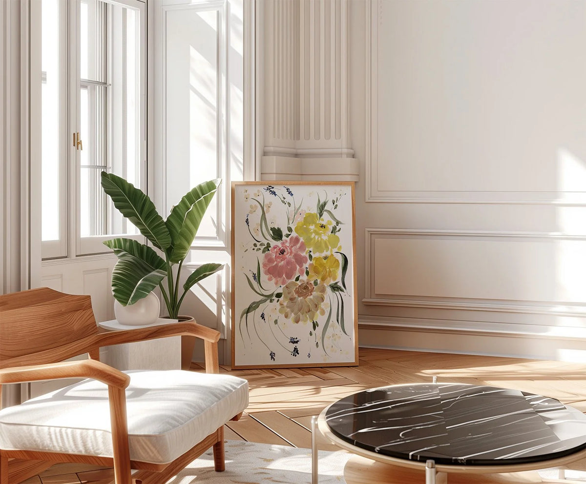 Ranunculus bouquet print leaning in a bright living room beside a potted plant and wooden chair.