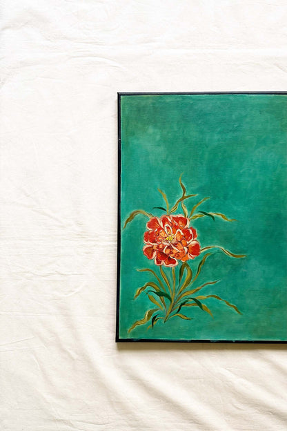 A framed painting featuring a vibrant red and orange flower with green leaves on a textured teal background Original artwork by Ramya Rajiv