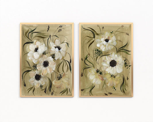 Pair of gold-framed prints of white anemones with dark centers on golden olive backgrounds.