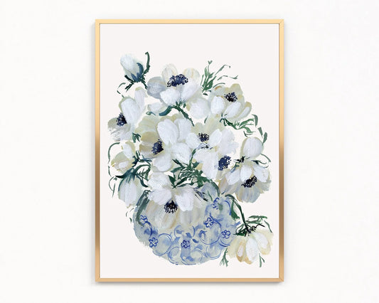 Gold-framed print of white anemones with dark blue centers in a blue-patterned vase.