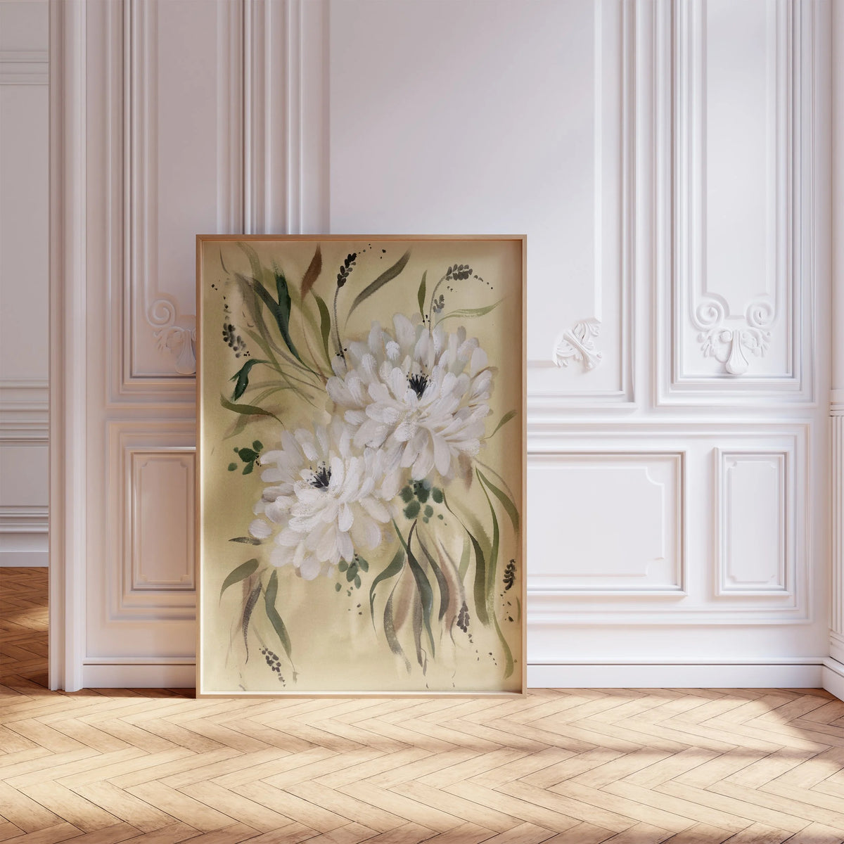 Large white dahlia print in a light frame leaning against ornate white wall molding.
