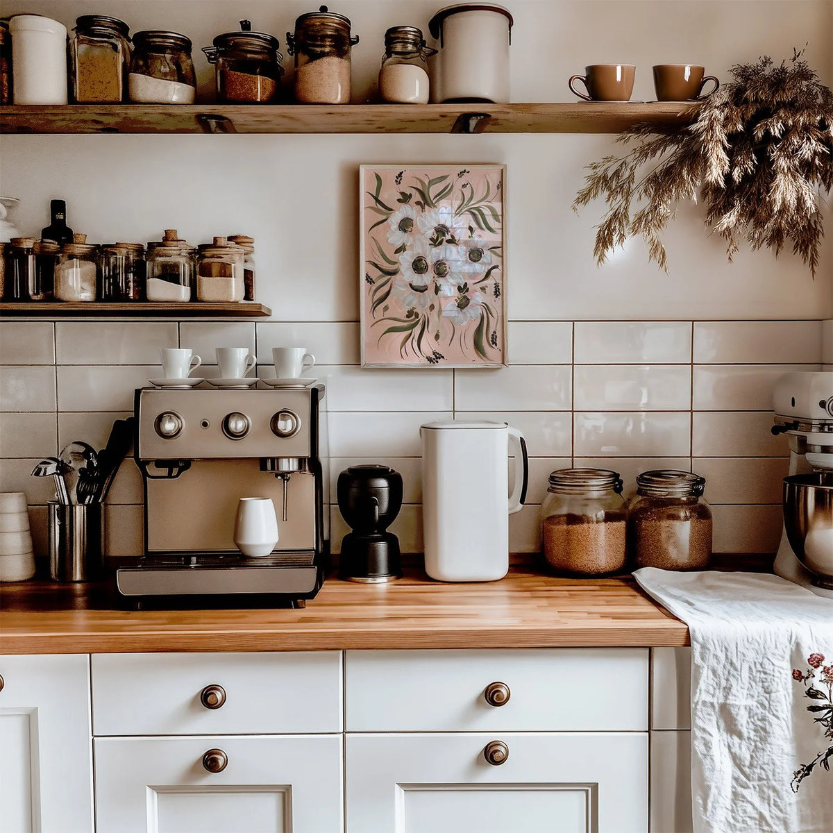 White anemone print on peach above a kitchen counter with an espresso machine and storage jars.