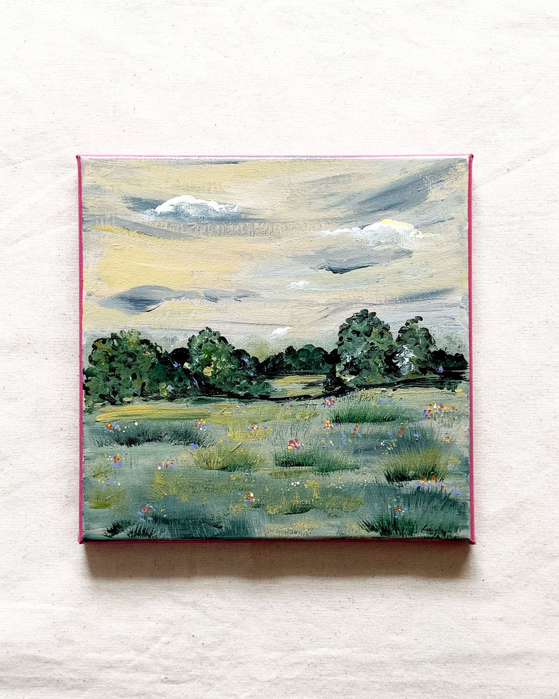A square canvas painting of a landscape with a grassy field, trees, and a cloudy sky, 