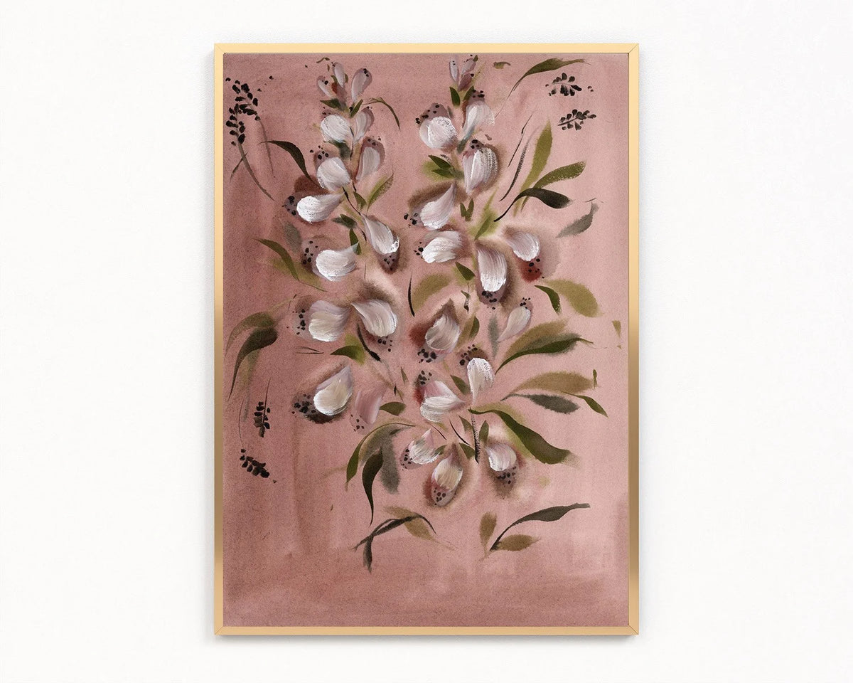 A framed floral art print featuring white blossoms and green leaves on a dusty pink background, enclosed in a light wood frame against a white wall.