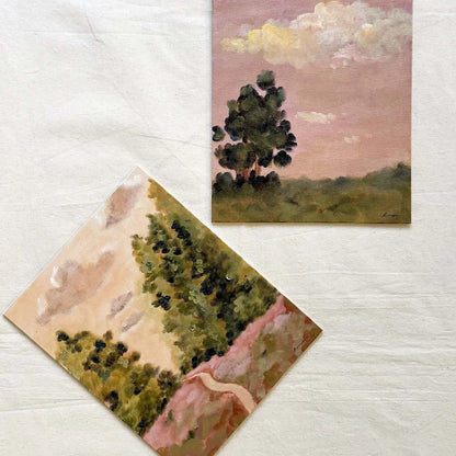 Two small original landscape paintings, one showing a tree under a pink sky and the other showing trees and a pale path