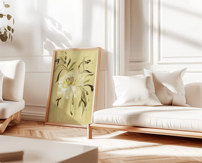 White peony print on gold leaning beside a white sofa in a sunlit room.